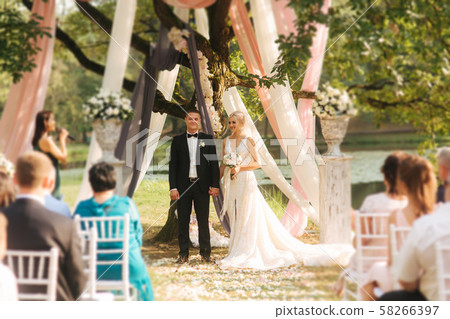 Wedding couple on ceremony outside. beautiful bride and handsome groom. Just married 58266397