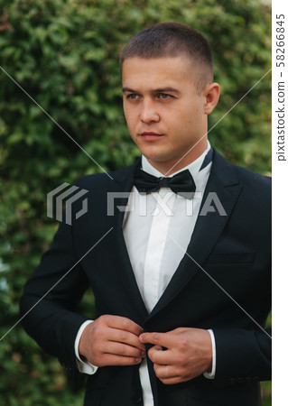 Handsome groom dressed his wedding blazer. autumn weather Handsome groom dressed his wedding blazer. autumn weather 58266845