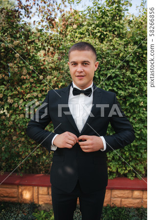 Handsome groom dressed his wedding blazer. autumn weather Handsome groom dressed his wedding blazer. autumn weather 58266856