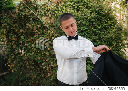 Handsome groom dressed his wedding blazer. autumn weather Handsome groom dressed his wedding blazer. autumn weather 58266863
