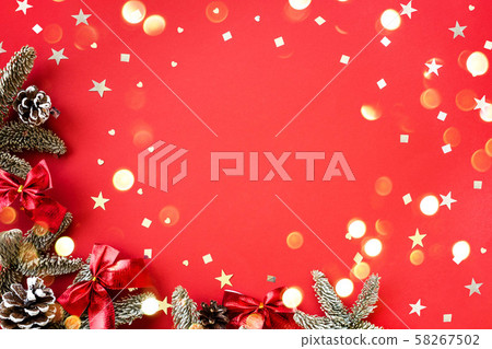 Christmas composition of fir branches and cones with shiny confetti on a red background. Christmas composition of fir branches and cones with shiny confetti on a red background. 58267502