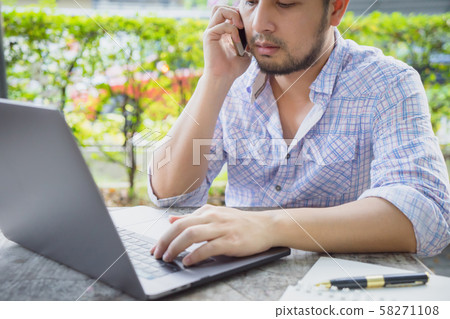 Business man talking on phone working with laptop. Business man talking on phone working with laptop. 58271108