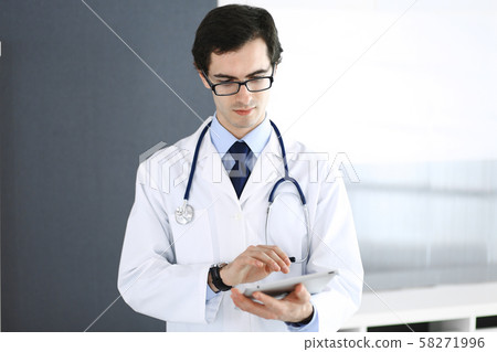 Doctor man using tablet computer for network research or virtual disease treatment. Perfect medical Doctor man using tablet computer for network research or virtual disease treatment. Perfect medical 58271996