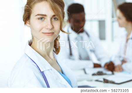 Happy doctor woman with medical staff at the hospital. Multi ethnic people group Happy doctor woman with medical staff at the hospital. Multi ethnic people group 58273105