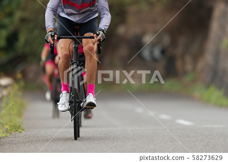 Cycling competition,cyclist athletes riding a race,climbing up a hill on a bicycle 58273629