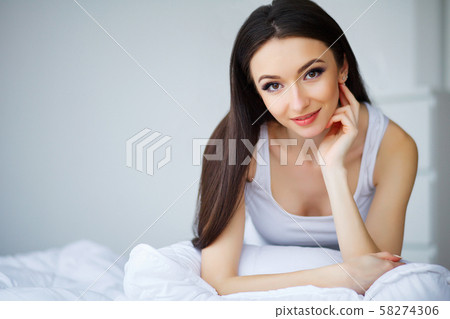 Healthy Happy Female Model Relaxing Indoors. Portrait of a smiling pretty young brunette woman 58274306