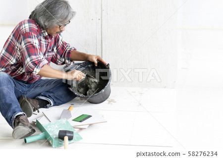 Senior mason craftsman preparing tile work by using cement in site. Senior mason craftsman preparing tile work by using cement in site. 58276234
