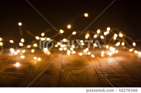 Defocus christmas lights on wooden background. 58276366