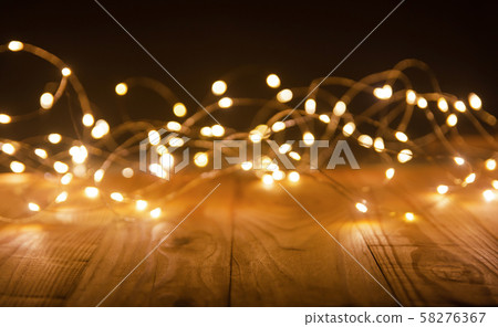 Defocus christmas lights on wooden background. 58276367