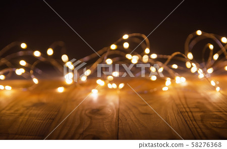 Defocus christmas lights on wooden background. Defocus christmas lights on wooden background. 58276368