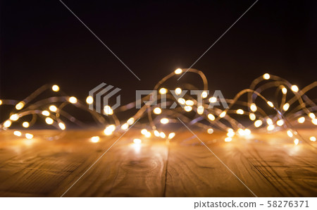 Defocus christmas lights on wooden background. Defocus christmas lights on wooden background. 58276371