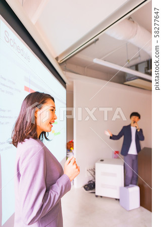 Business image: A scene that explains the system development schedule to the orderer in a good teamwork with colleagues Business image: A scene that explains the system development schedule to the orderer in a good teamwork with colleagues 58277647
