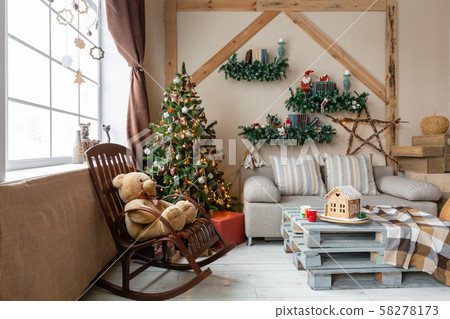 Christmas morning in the bright living room. Homemade gingerbread house on background room decorated 58278173