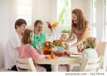 Family with kids at Thanksgiving dinner. Turkey. 58278444