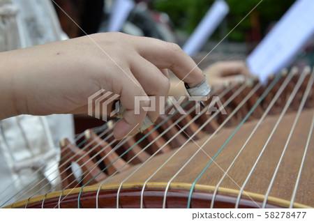 a child is playing a guzheng 58278477