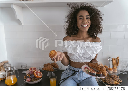Young woman being happy to eat some sweets 58278478