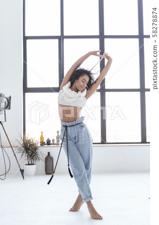 Happy young woman enjoying her dancing alone Happy young woman enjoying her dancing alone 58278874