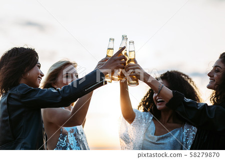 Young people standing with beer bottles  58279870