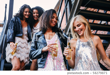 Young people standing with beer bottles  58279871