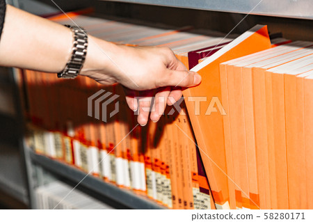 Close up womans hand selecting book from bookshelf Close up womans hand selecting book from bookshelf 58280171