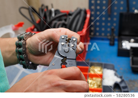 The wizard is preparing a new electrical wire to replace the damaged one on the motorcycle. The wizard is preparing a new electrical wire to replace the damaged one on the motorcycle. 58280536