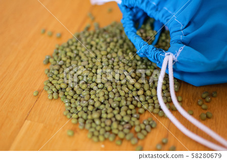 Close up of green mung bean vigna radiata in blue reusable package on wooden background. Eco Close up of green mung bean vigna radiata in blue reusable package on wooden background. Eco 58280679