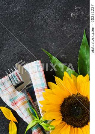 Autumn table place setting, cutlery with napkin and sunflower.  58281227
