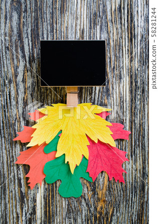 Autumn background: chalk board with colorful paper leaves on vintage textured wooden background.  58281244