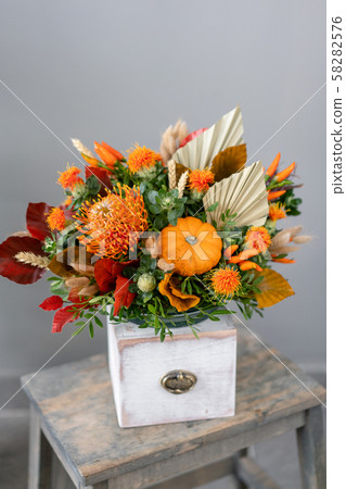 Autumn bouquet of mixed flowers on wooden table. The work of the florist at a flower shop. Fresh cut 58282576