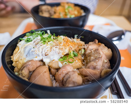Katsudon is a popular Japanese food, a bowl of rice topped with a deep-fried pork cutlet, egg, vegetables, and condiments. 58288540