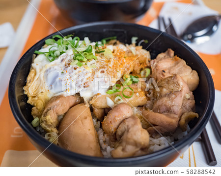 Katsudon is a popular Japanese food, a bowl of rice topped with a deep-fried pork cutlet, egg, vegetables, and condiments. Katsudon is a popular Japanese food, a bowl of rice topped with a deep-fried pork cutlet, egg, vegetables, and condiments. 58288542