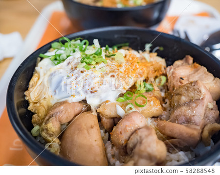 Katsudon is a popular Japanese food, a bowl of rice topped with a deep-fried pork cutlet, egg, vegetables, and condiments. Katsudon is a popular Japanese food, a bowl of rice topped with a deep-fried pork cutlet, egg, vegetables, and condiments. 58288548