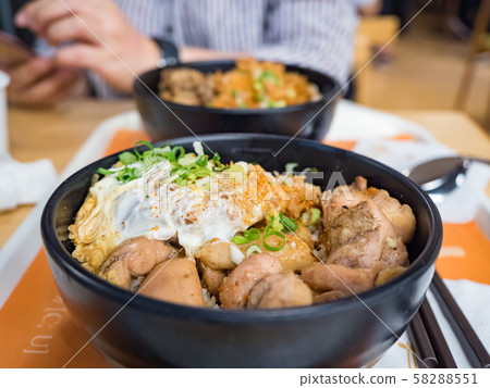Katsudon is a popular Japanese food, a bowl of rice topped with a deep-fried pork cutlet, egg, vegetables, and condiments. Katsudon is a popular Japanese food, a bowl of rice topped with a deep-fried pork cutlet, egg, vegetables, and condiments. 58288551