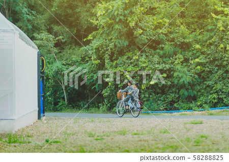 Back view of happiness two brothers wear military camouflage shirts ride bicycle at modern organic farmhouse Back view of happiness two brothers wear military camouflage shirts ride bicycle at modern organic farmhouse 58288825