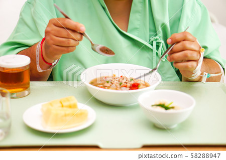 Asian  lady woman patient eating breakfast healthy food with hope and happy while sitting and hungry on bed in hospital. 58288947
