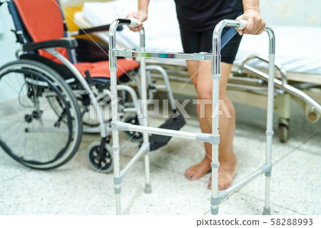 Asian middle-aged lady woman patient walk with walker at nursing hospital ward Asian middle-aged lady woman patient walk with walker at nursing hospital ward 58288993
