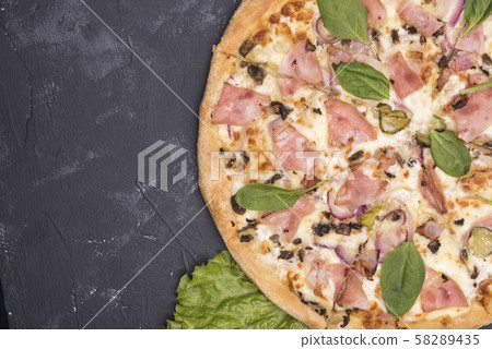 pizza with bacon and greens on a dark background 58289435