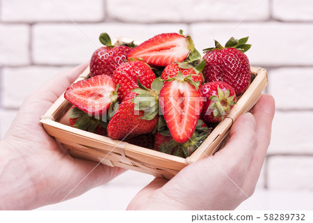 bowl of ripe strawberries in the girl's hands bowl of ripe strawberries in the girl's hands 58289732