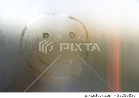 handmade inscription on the sweaty glass smiley. 58289856