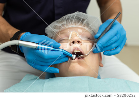 Closeup of dentist operation over young boy's teeths 58290252