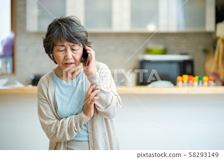Senior woman talking on an uneasy senior smartphone, silver generation elderly woman portrait Senior woman talking on an uneasy senior smartphone, silver generation elderly woman portrait 58293149