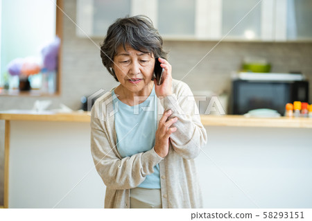 Senior woman talking on an uneasy senior smartphone, silver generation elderly woman portrait Senior woman talking on an uneasy senior smartphone, silver generation elderly woman portrait 58293151