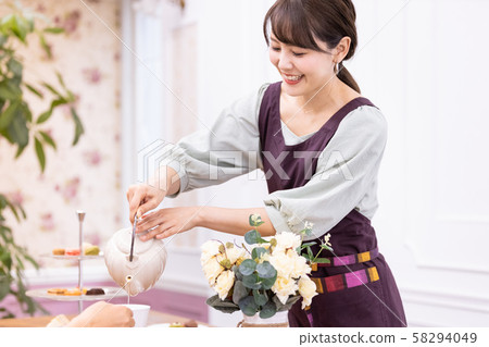 A woman who pours tea 58294049