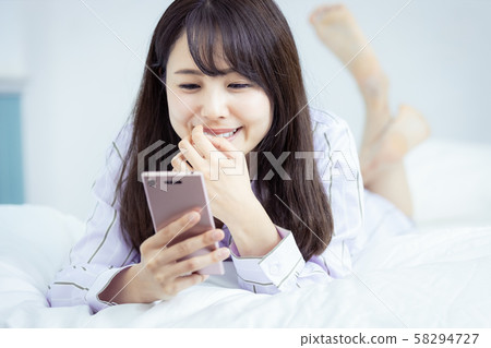 女性智能手機,臥室服裝,微笑 女性智能手機,臥室服裝,微笑 58294727
