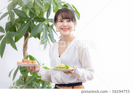 Young woman carrying meal 58294755