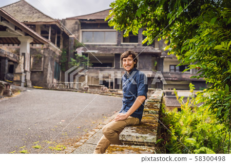 Man tourist in abandoned and mysterious hotel in Bedugul. Indonesia, Bali Island. Bali Travel Man tourist in abandoned and mysterious hotel in Bedugul. Indonesia, Bali Island. Bali Travel 58300498