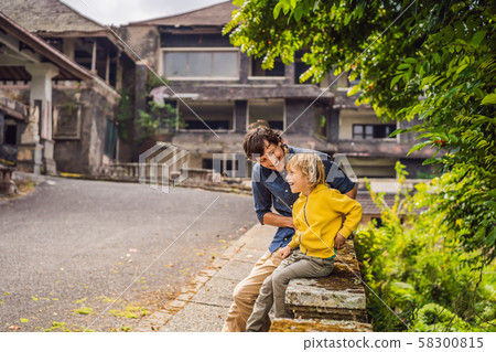 Dad and son tourists in abandoned and mysterious hotel in Bedugul. Indonesia, Bali Island. Bali 58300815