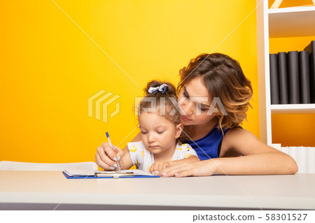 Female tutor with little girl doing homework. Preschool concept. 58301527