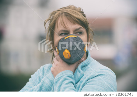 Woman wearing a real anti-pollution, anti-smog and 58301743