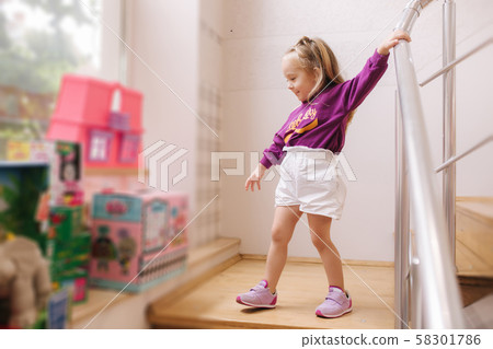 Happy little girl walkning in toy store. Cute girl choose toy. Adorable female in kids mall 58301786